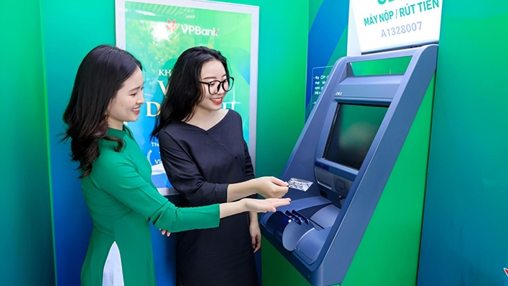 Nhân viên ngân hàng VPBank đang hướng dẫn khách hàng sử dụng máy CDM