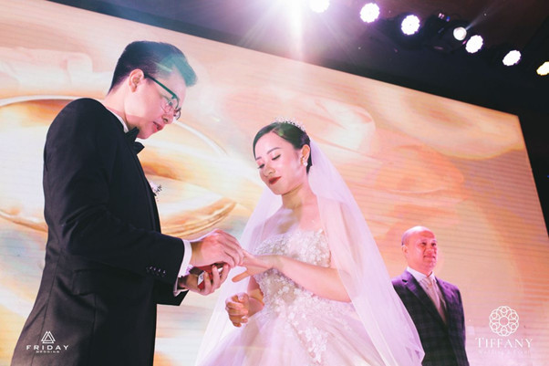 Cô dâu và chú rể trao nhẫn cưới, biểu tượng của tình yêu và sự gắn kết vĩnh cửu.