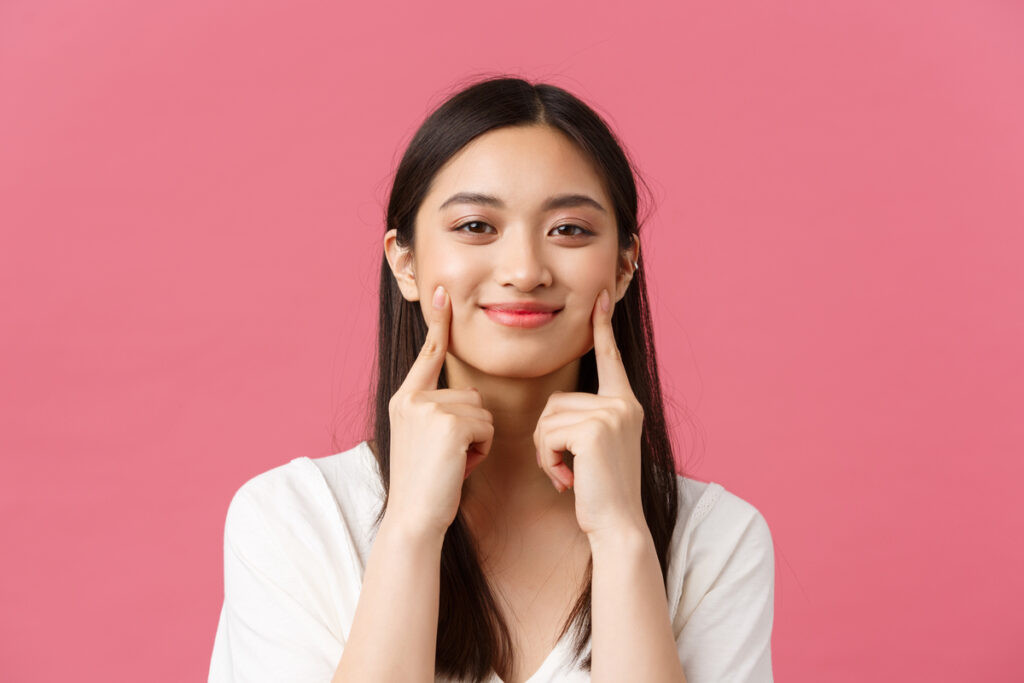 Người phụ nữ châu Á tươi cười rạng rỡ, minh họa cho sự thông minh và nhanh nhẹn, nhưng không phải là khôn lỏi.