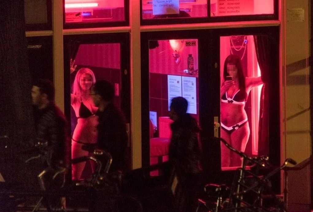 Gái mại dâm đứng sau ô cửa kính ở De Wallen, Amsterdam
