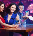 Cô gái xinh đẹp cười rạng rỡ, tay cầm ly nước trong một quán bar sang trọng